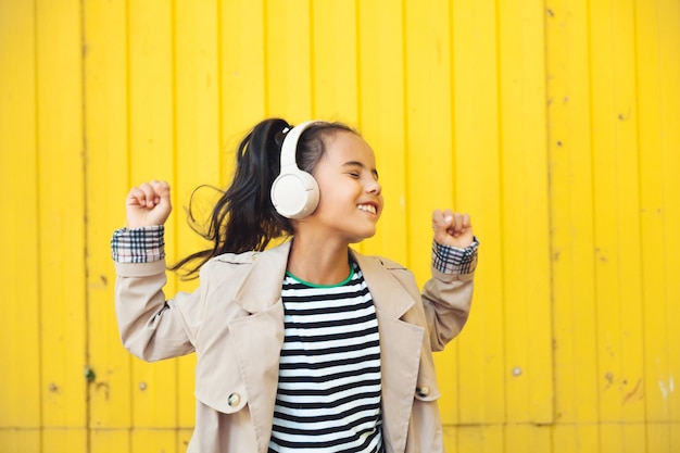 Un enfant avec des écouteurs écoutant de la musique Concept de livre audio Apprendre des leçons audio une petite fille wi