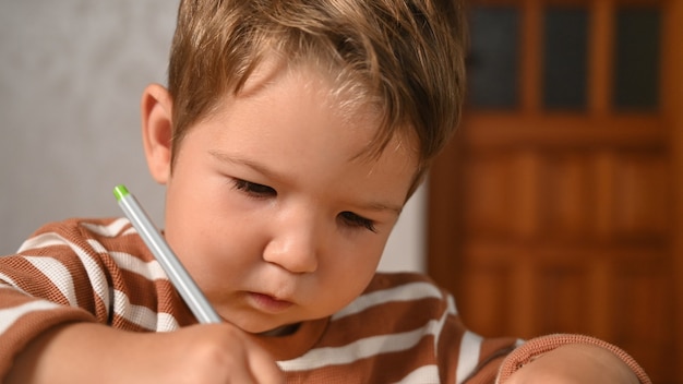 L'enfant écrit avec concentration.