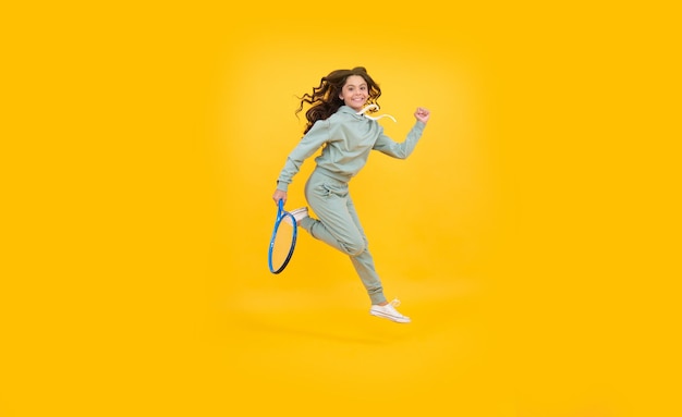 Enfant énergique avec raquette de tennis. adolescente courir à la formation. dédié à la remise en forme. joueur de tennis ou de badminton. mode de vie sain et actif. succès sportif. enfance heureuse. enfant saute avec une raquette.