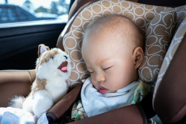 Enfant enfant garçon asiatique dormir dans le siège d'auto. Sécurité des enfants voyageant sur la route. Un moyen sûr de voyager avec les ceintures de sécurité attachées dans le véhicule avec le concept de jeune enfant