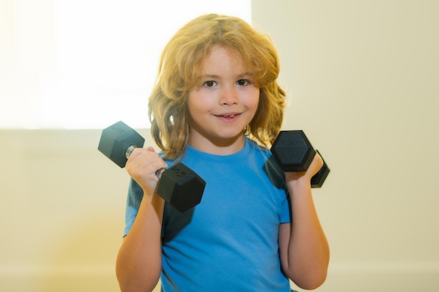 Enfant entraînement enfant dans la salle de gym Enfant garçon travaillant avec des haltères Sport et entraînement pour enfants