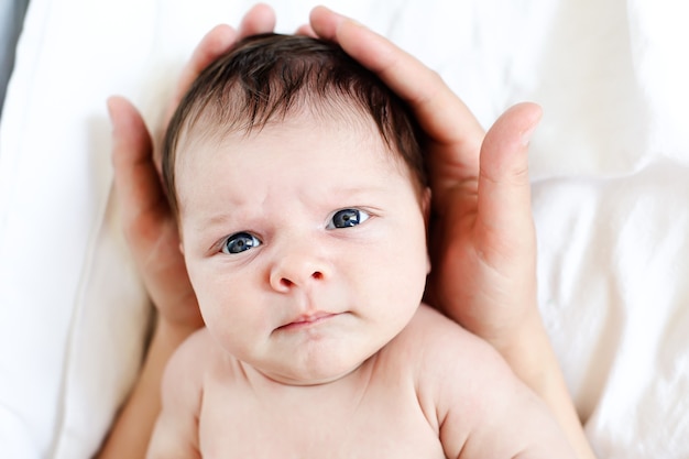 L'enfant entre les mains douces de sa mère