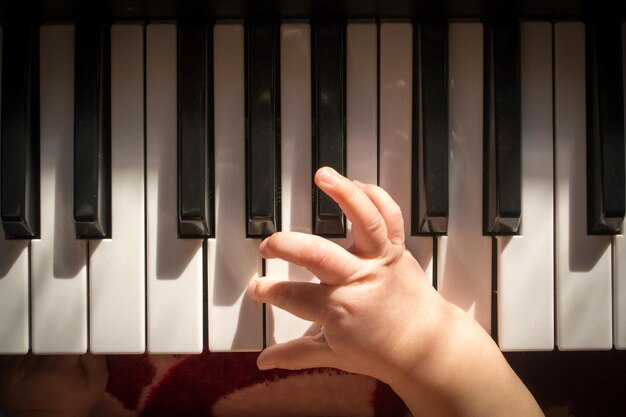 Photo enfant essayant de jouer du synthétiseur