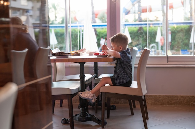 L'enfant est assis seul dans un restaurant.