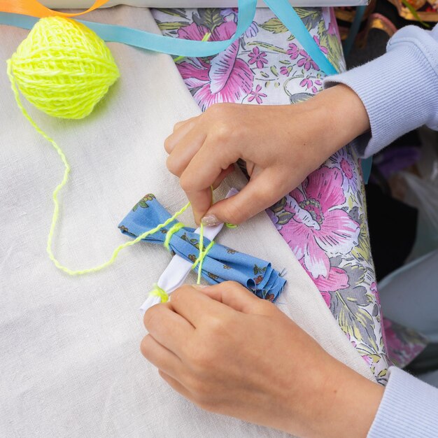 L'enfant est engagé dans l'art populaire finition la poupée amulette de textiles appelé Kuvadka un