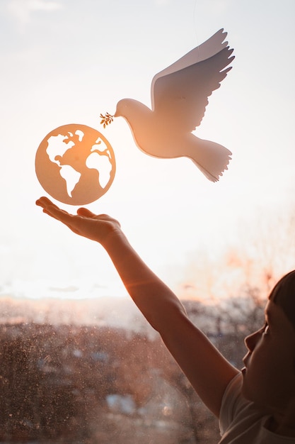 Photo enfant étend ses mains du soleil à l'extérieur de la fenêtre flying dove world avec les forces de la direction générale concept monde monde de la paix sans l'écologie de la guerre