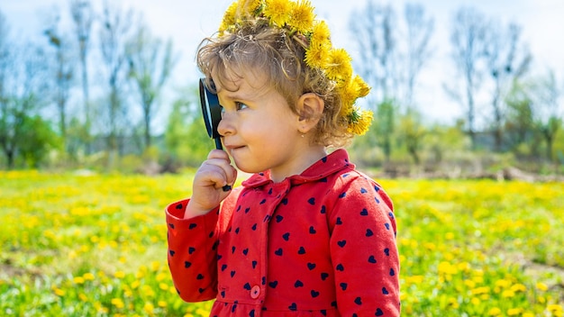 Un enfant examine les plantes avec une loupe Mise au point sélective