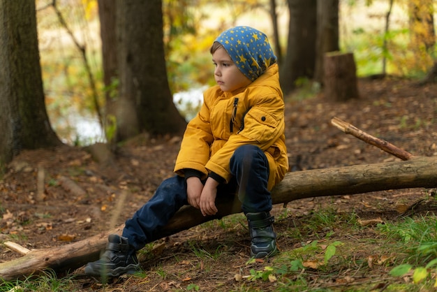 L'enfant explore la forêt et s'assit pour se reposer