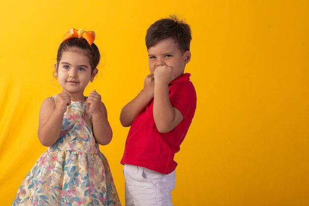 Enfant avec des expressions faciales dans une photo de studio sur fond coloré.