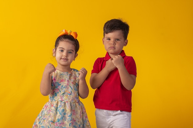 Enfant avec des expressions faciales dans une photo de studio sur fond coloré.