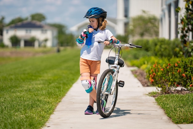 Enfant faisant du vélo dans un casque enfant avec un vélo pour enfants et dans des articles de casque de protection sur la sécurité et