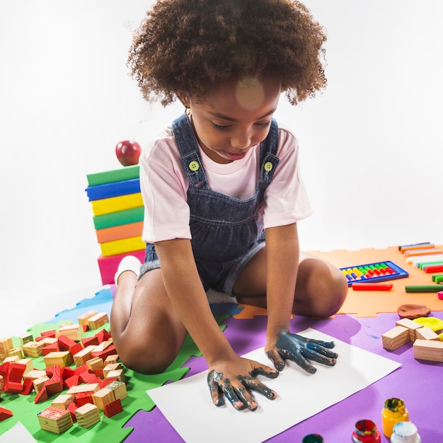 Enfant faisant des empreintes de main sur papier en studio