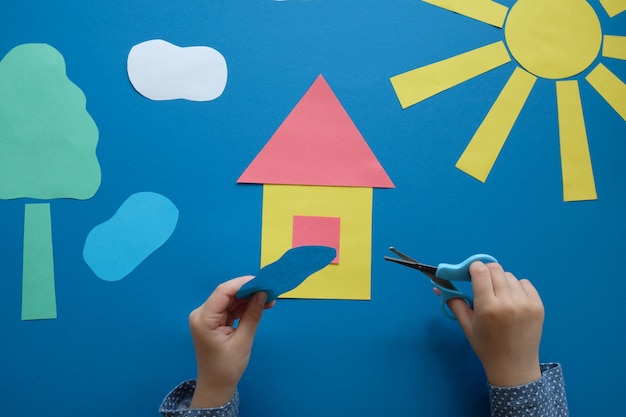 L'enfant fait une applique à partir de papier de couleur