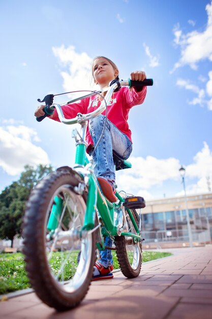 Enfant fait du vélo dans un parc d'été