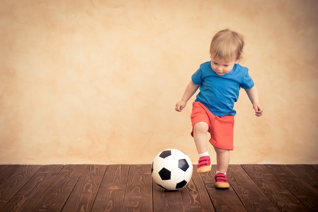 L'enfant fait semblant d'être un joueur de football. Concept de réussite et de gagnant