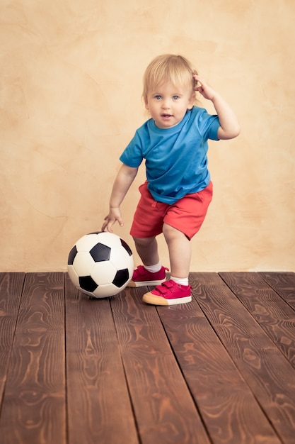 L'enfant fait semblant d'être un joueur de football. Concept de réussite et de gagnant