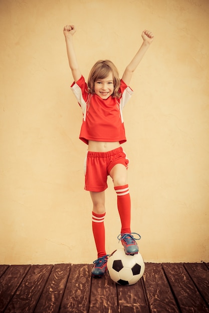 L'enfant Fait Semblant D'être Un Joueur De Football. Concept De Réussite Et De Gagnant