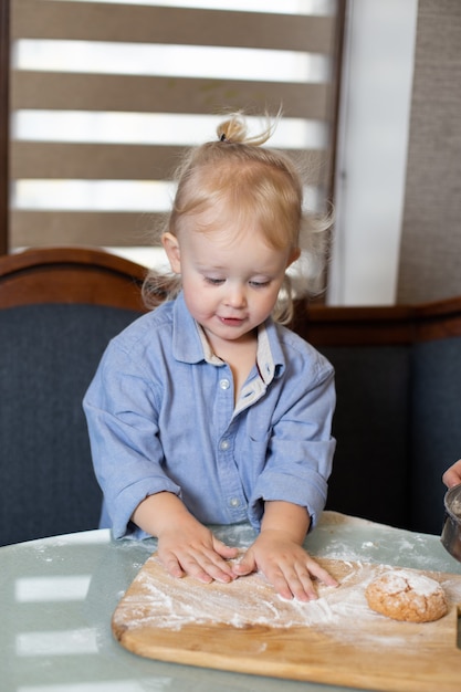 Un enfant en farine dans la cuisine.