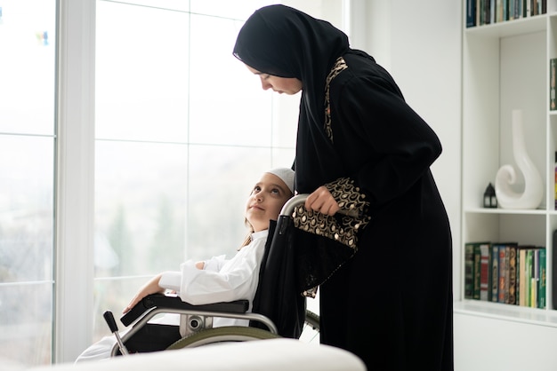 Enfant en fauteuil roulant arabe avec sa mère à la maison