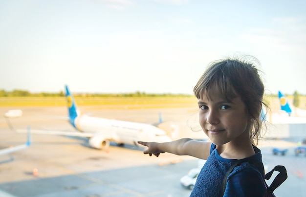 Une enfant fille à l'aéroport regarde les avions