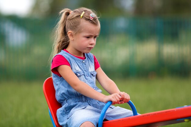 Enfant fille assise sur une balançoire