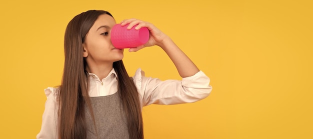 Enfant fille assoiffée boire une boisson à partir d'une tasse en plastique tenant un panneau publicitaire pour l'espace de copie soif Conception d'affiches horizontales Espace de copie d'en-tête de bannière Web