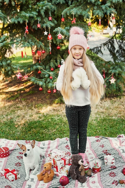 enfant fille avec chien près de l'arbre de Noël avec des cadeaux