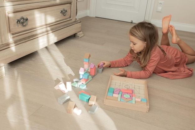 Enfant fille construit une tour de cubes colorés pastel en bois Jeux éducatifs pour le développement des enfants