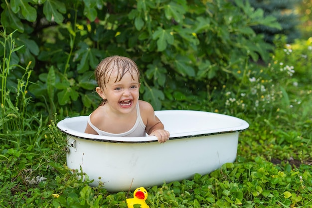 Photo une enfant fille dans un bain rétro baigne dans la nature et rit.