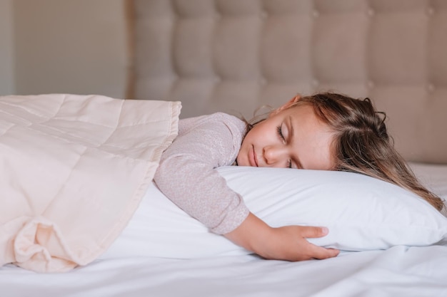 Photo enfant fille dort sur un lit douillet blanc