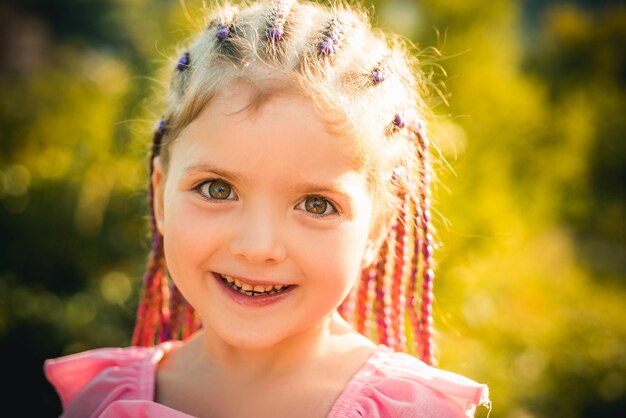 Enfant fille avec des dreadlocks de corde de cheveux élégants Enfant avec une coiffure à la mode sur fond flou en plein air Enfants beauté et mode