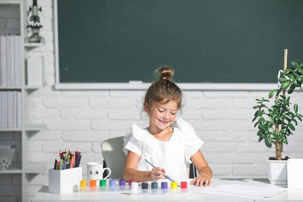 Enfant fille à l'école dessine avec des peintures Créativité des artistes pour enfants Croissance créative des enfants