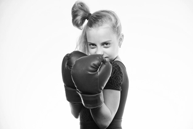 Enfant fille avec des gants bleus posant sur fond blanc Éducation sportive Éducation pour le leadership et gagnant Boxe enfant fort Concept sport et santé Sport de boxe pour femme Soyez fort