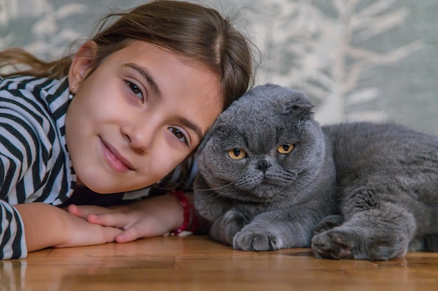 Enfant fille à la maison avec un chat. Mise au point sélective.