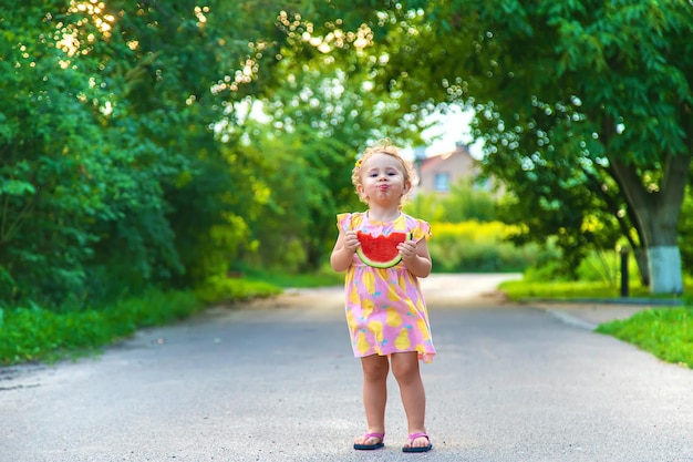 Enfant fille mange de la pastèque en été Mise au point sélective