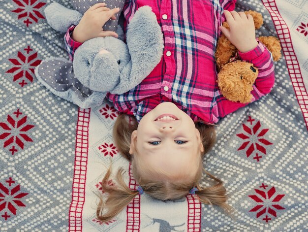 enfant fille avec peluches sur un plaid, Noël en juillet sur la nature