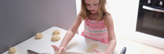 Enfant fille avec un rouleau à pâtisserie pour faire des biscuits pour la pâte