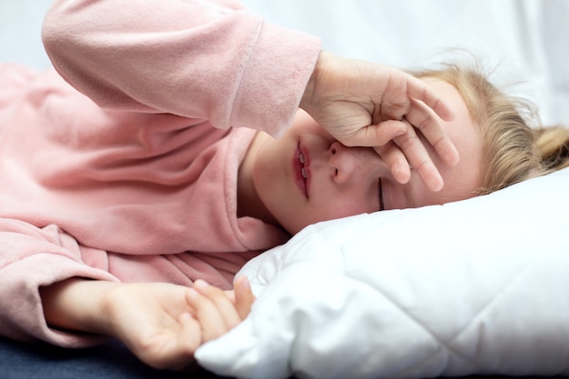 Photo enfant fille se frotte les yeux et veut dormir