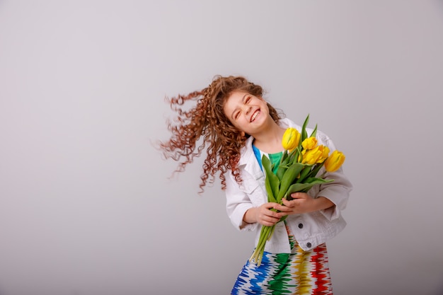 Un enfant une fille tenant un bouquet de tulipes jaunes