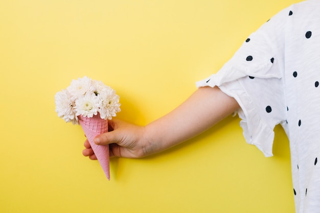 Enfant avec des fleurs en cône