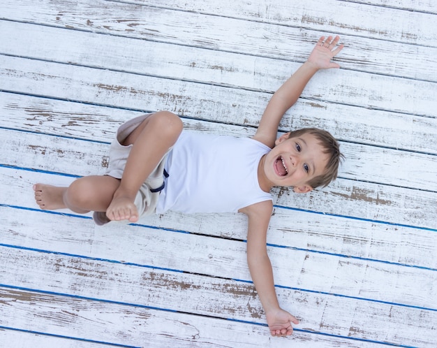 Enfant sur un fond en bois blanc