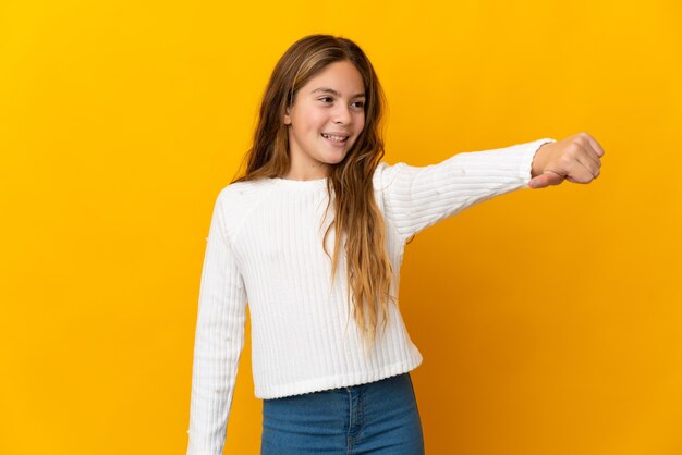 Enfant sur fond jaune isolé donnant un coup de pouce geste