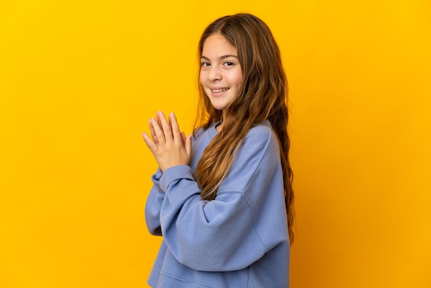 Enfant sur fond jaune isolé intrigant quelque chose