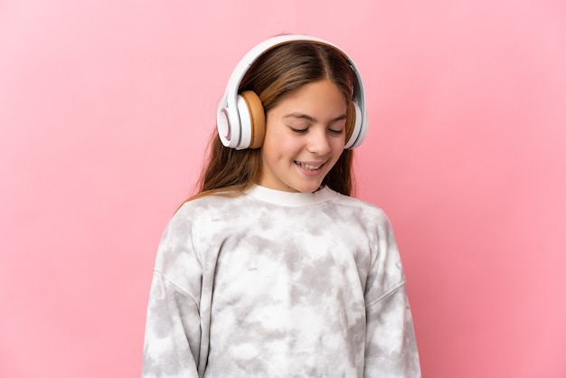 Enfant sur fond rose isolé écouter de la musique