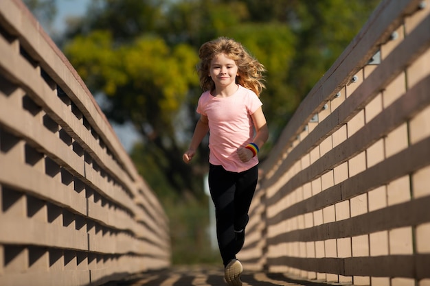 Enfant garçon faisant du jogging dans le parc en plein air