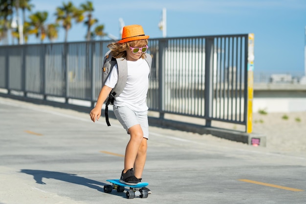 Enfant garçon faisant du skateboard sur la route enfant pratiquant le skateboard les enfants apprennent à faire du skateboard dans