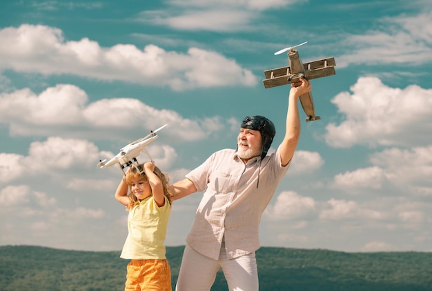 Enfant garçon et grand-père avec avion et drone quadcopter sur fond bleu ciel et nuages hommes ge