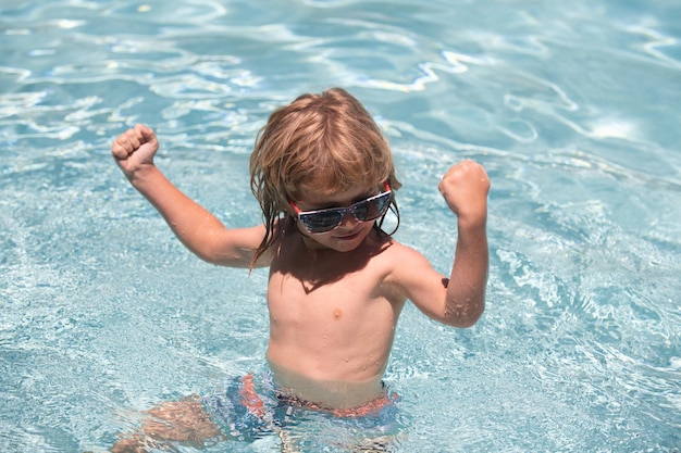 Enfant garçon montrer les muscles nager dans la piscine