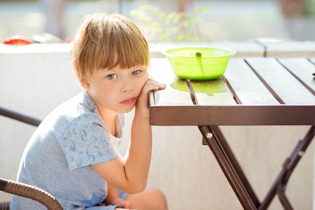 L'enfant garçon ne veut pas manger, refuse de manger, fait des grimaces