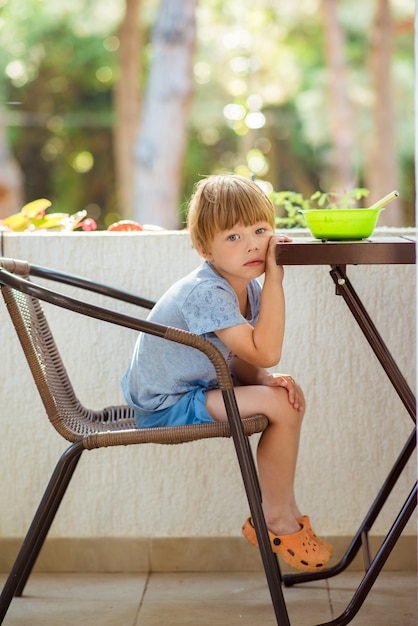 L'enfant garçon ne veut pas manger, refuse de manger, fait des grimaces